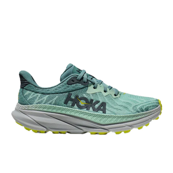 The HOKA Womens Challenger ATR 7 Wide in Mist Green/Trellis features a teal all-terrain design with a thick gray sole, yellow outsole accents, and the HOKA logo in dark lettering, shown side profile on a white background.