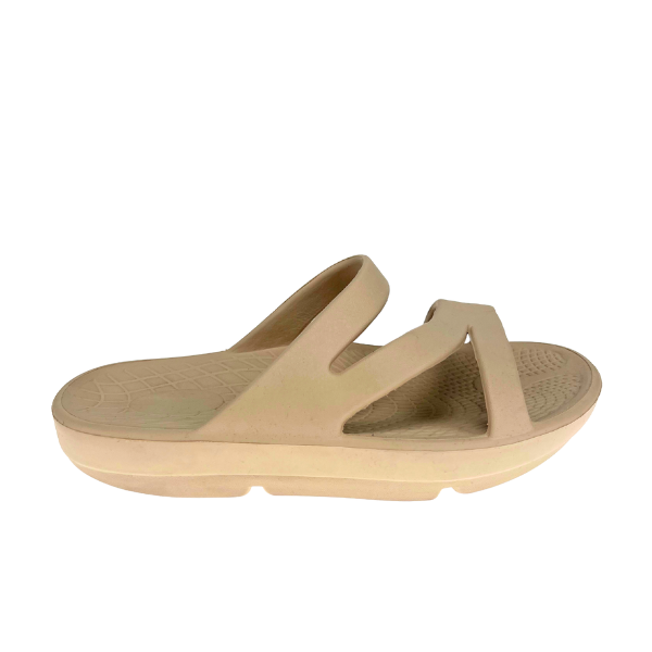 The SOVELLA Sovella Womens PF Slide Beige features two Wide straps, a textured footbed, thick cushioned sole, and arch support. Shown in side view on a white background.