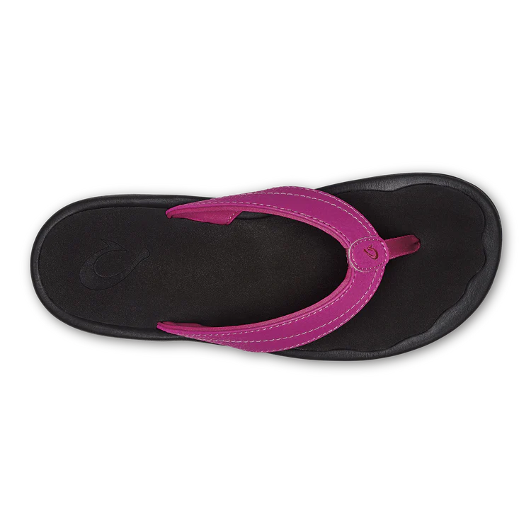 A top-down view of the OLUKAI W-Ohana Orchid flip-flop sandal in black with a Wide magenta strap and visible stitching, designed for anatomical comfort.