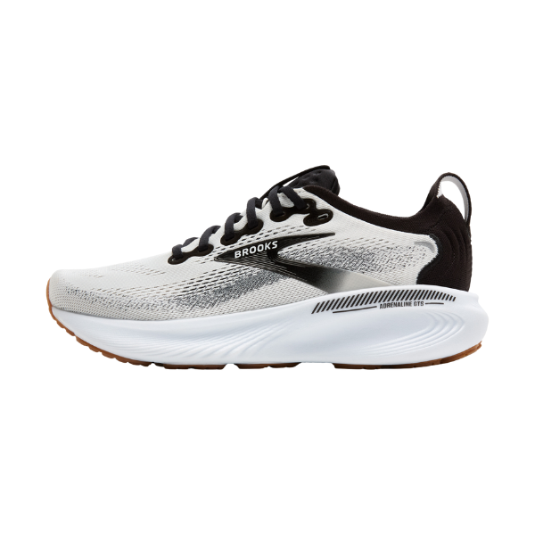 The BROOKS Women's Adrenaline GTS 25 Wide White/Black features a mesh upper, black laces and heel, and a white cushioned sole with wavy design—ideal for support and comfort on every run.