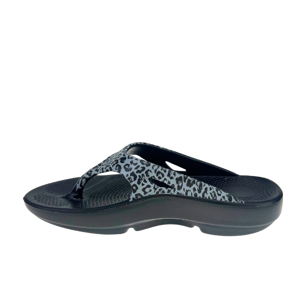 The Sovella Womens PF Thong Black/Leopard by SOVELLA features a black sole, gray and black leopard print strap, textured footbed, and built-in arch support, shown in side profile on a white background.