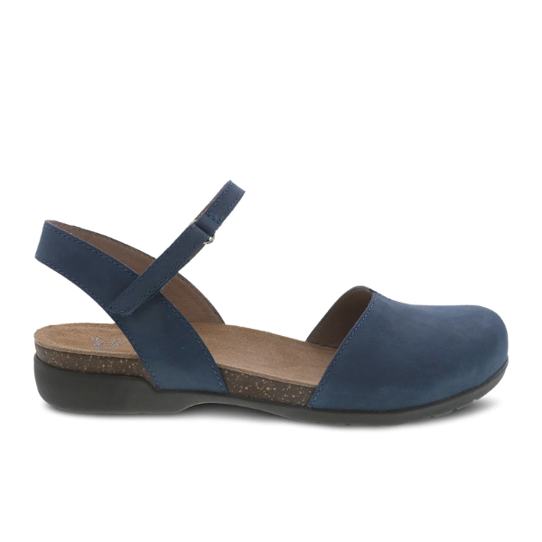 The DANSKO Womens Rowan Navy sandal features a blue closed-toe design, adjustable ankle strap, memory foam insole over cushioned cork footbed, and black sole, shown in side profile.