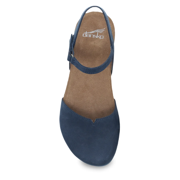 The Dansko Womens Rowan Navy flat sandal by DANSKO features a closed toe, brown memory foam insole for comfort, and adjustable back strap, shown from a top-down view.