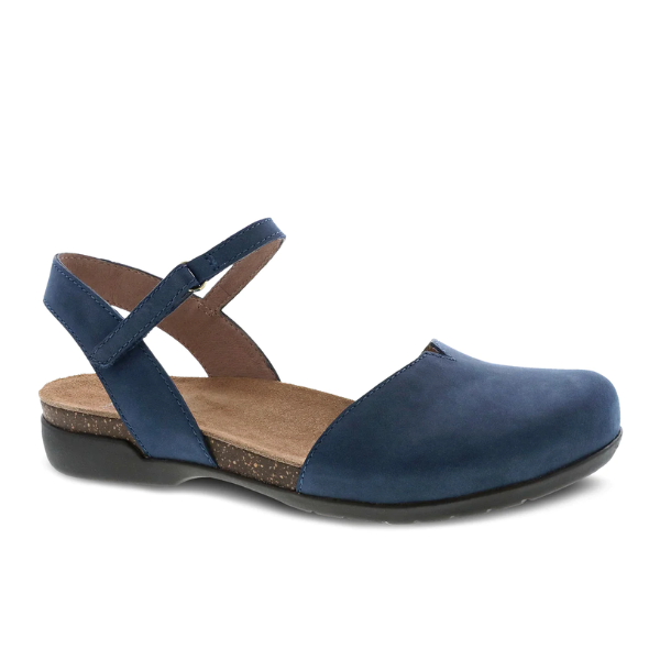 The Dansko Womens Rowan Navy by DANSKO is a navy closed-toe sandal with a low black sole, ankle strap with buckle, and cushioned brown memory foam insole for all-day comfort and support.