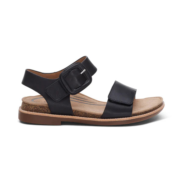Aetrex Women's Claire Black sandals by AETREX WORLDWide INC feature a cork sole, two adjustable straps with a large buckle, a flat brown rubber outsole, and are designed for comfort and excellent arch support.