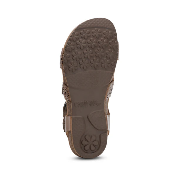 Bottom view of the Aetrex Womens Lilly Cutout Taupe by AETREX WORLDWide INC, featuring a floral tread sole with Aetrex embossed—crafted for comfort with arch support and a memory foam footbed.