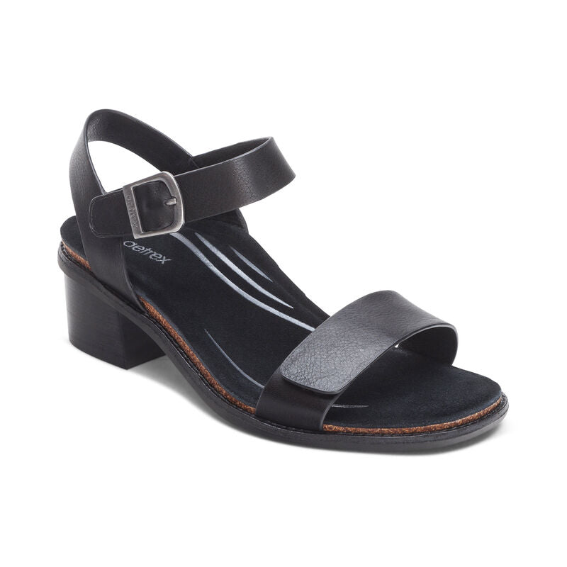The Aetrex Womens Mae Black by AETREX WORLDWide INC is a black open-toe sandal with a low block heel, adjustable buckle quarter strap, Wide front strap, and an anatomically cushioned insole with subtle white lines for added style and comfort.