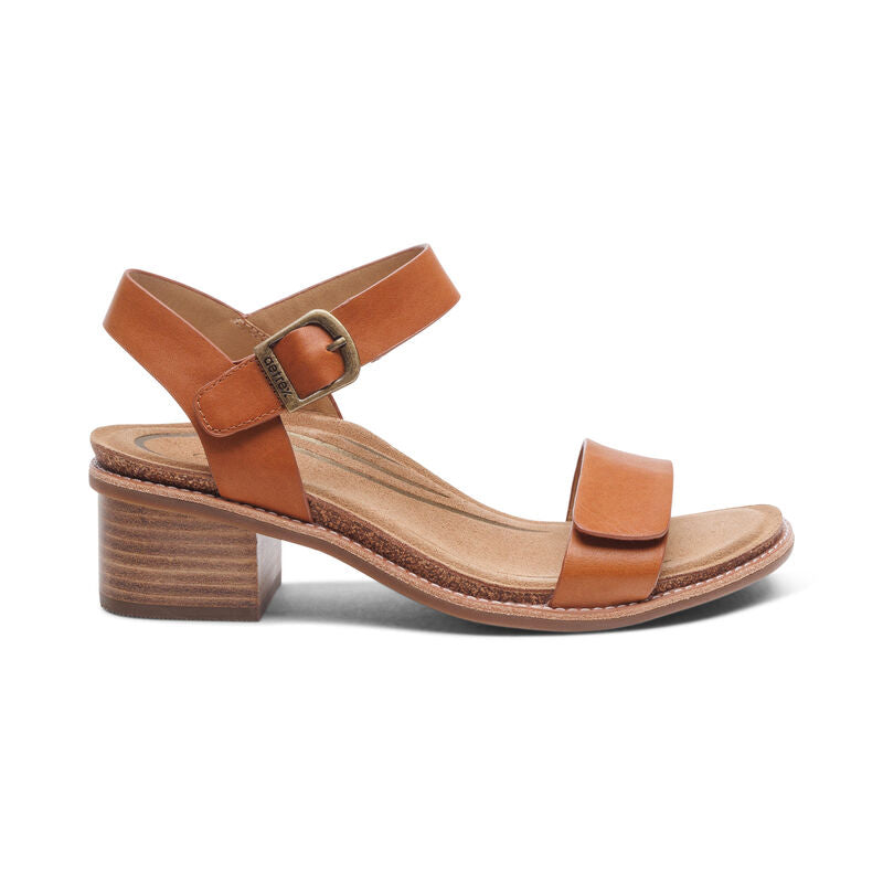 The Aetrex Womens Mae Cognac sandal by AETREX WORLDWide INC features a leather upper, ankle strap with buckle, open toe, low block wooden heel, and a cushioned insole for comfort.