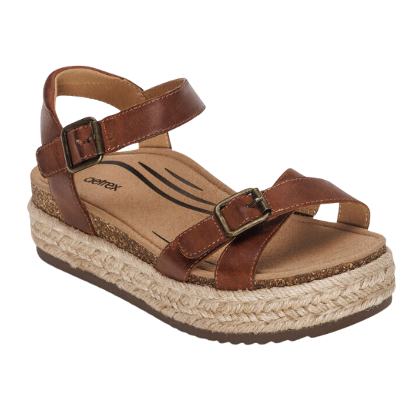 The Aetrex Womens Paula Walnut by AETREX WORLDWide INC is a brown leather sandal with adjustable straps, cork footbed, platform sole wrapped in braided jute, arch support for comfort, and a durable brown rubber outsole.