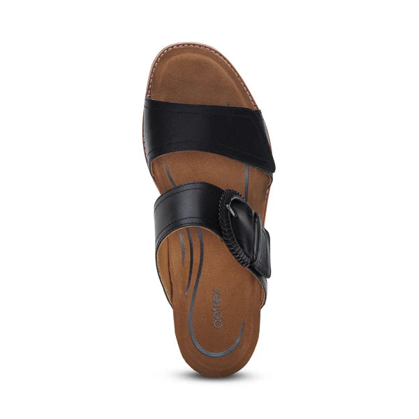 The Aetrex Womens Tatiana Black sandal by AETREX WORLDWide INC features a brown and black design with two leather straps—one plain, one with a decorative buckle—and a comfortable low wedge heel, shown from the top view. Perfect for all-day wear.