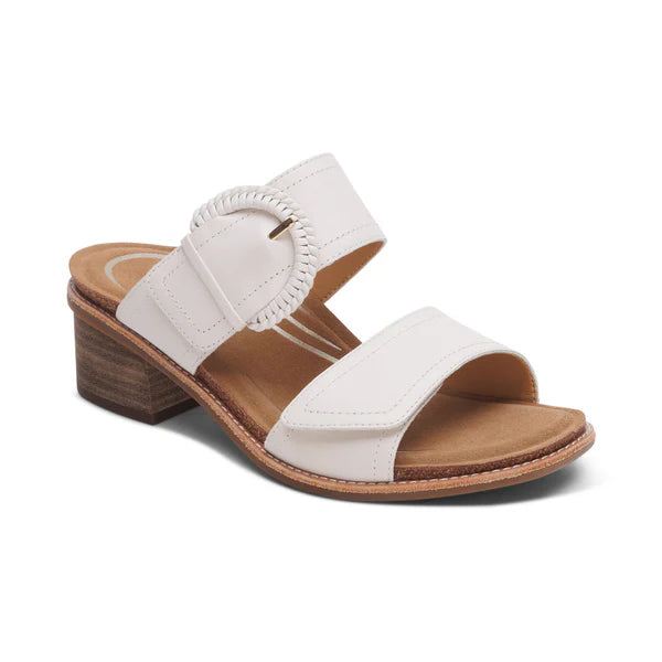 The Aetrex Womens Tatiana Ivory by AETREX WORLDWide INC is a white heeled sandal with two Wide straps, a round buckle, adjustable hook & loop closures, open toe, tan insole, and a low wooden block heel for comfort and pain relief.