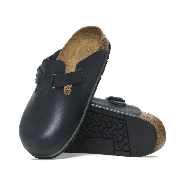 The BIRKENSTOCK Mens Boston Pro Leather Black features black leather uppers, a cork footbed, and a slip-resistant sole; one clog stands upright while the other is on its side, showing the tread pattern.