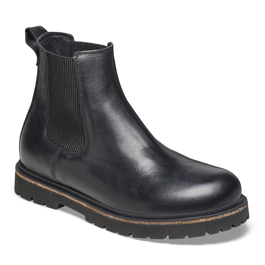 The BIRKENSTOCK Mens Highwood Slip On Black is a natural leather Chelsea boot with elastic side panels, pull tab, rounded toe, rugged rubber sole, and the signature Deep Blue Footbed for all-day comfort.