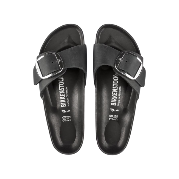 The Birkenstock Womens Madrid Big Buckle Black sandals feature oiled nubuck leather straps with large silver buckles and a cork footbed. Viewed from above on a white background, the insoles show the BIRKENSTOCK logo and sizing details.
