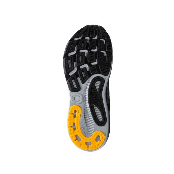 The image shows the sole of the BROOKS Mens Adrenaline GTS 24 Wide Grey running shoe, featuring a mostly black tread with a gray midsection and a yellow heel area, designed with textured patterns for traction and GuideRails® support.
