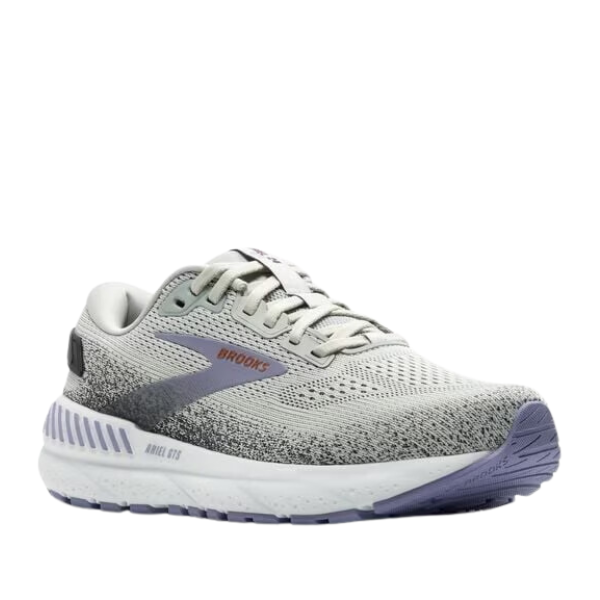 The BROOKS Womens Ariel GTS 24 Grey/Purple Wide is a gray and white running shoe with a gradient design, purple accents, and thick cushioned sole for support. Features the Brooks logo—ideal for those seeking comfort and style.