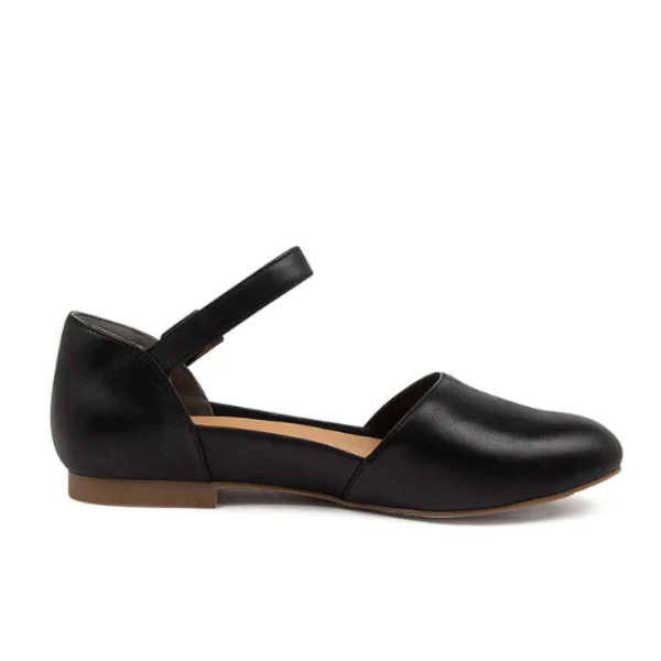 The ZIERA Womens Cavalcade Wide Black is a flat shoe with a closed toe, single ankle strap, low brown sole, and closed heel—side view shown. Inspired by foot pain relief and comfort.