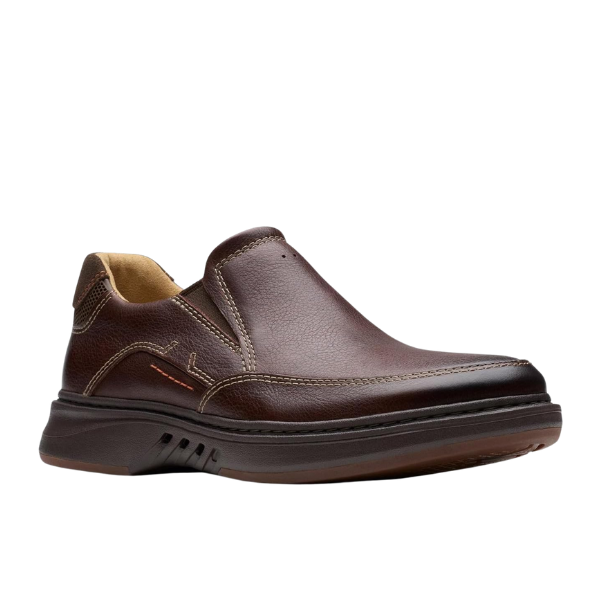 The CLARKS Mens Un Briley Step Leather Wide in Mahogany is a brown slip-on shoe with visible stitching, contoured footbeds, cushioned sole, slightly raised heel, and tan inner lining, shown on a white background.