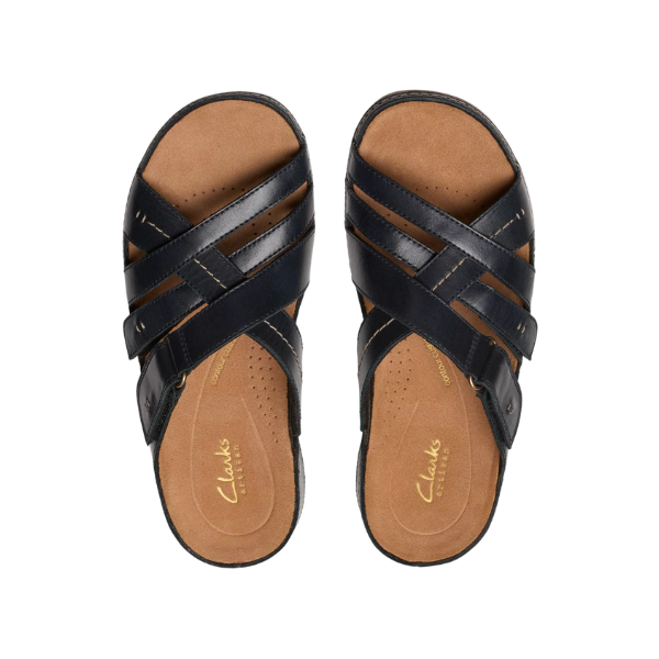The Clarks Womens Cecily Slide Leather Wide Black sandals by CLARKS feature black leather crisscross straps and a tan Contour Cushioned footbed, shown from above on a white background.