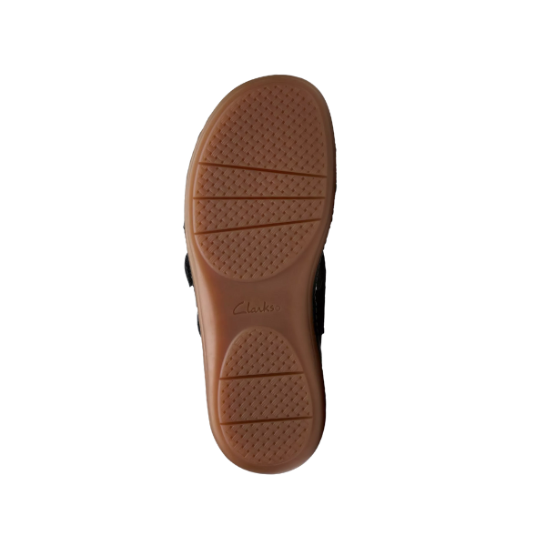 The image shows the sole of a CLARKS Womens Cecily Slide Leather Wide shoe in black, with a textured non-slip pattern and the CLARKS brand name engraved in the center on a white background.