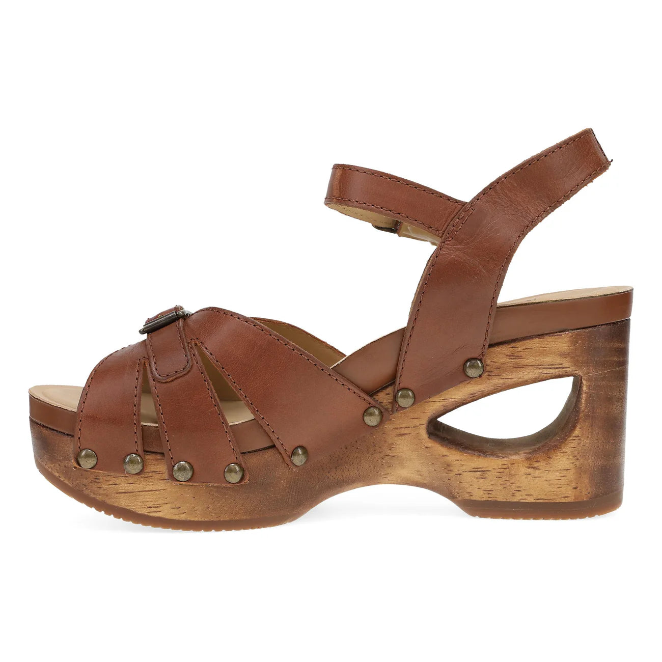 The DANSKO Womens Alanna Tan features a brown leather sandal with ankle strap, open toe, and studded accents. Its chunky wooden platform heel offers retro style and all-day comfort for foot pain relief.