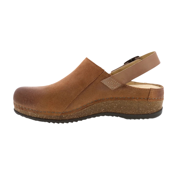 The Dansko Womens Merrin Tan by DANSKO is a sustainable leather mule clog in brown, featuring a closed toe, open heel, adjustable strap, visible stitching, textured wedge sole, and slightly elevated heel for foot pain relief.