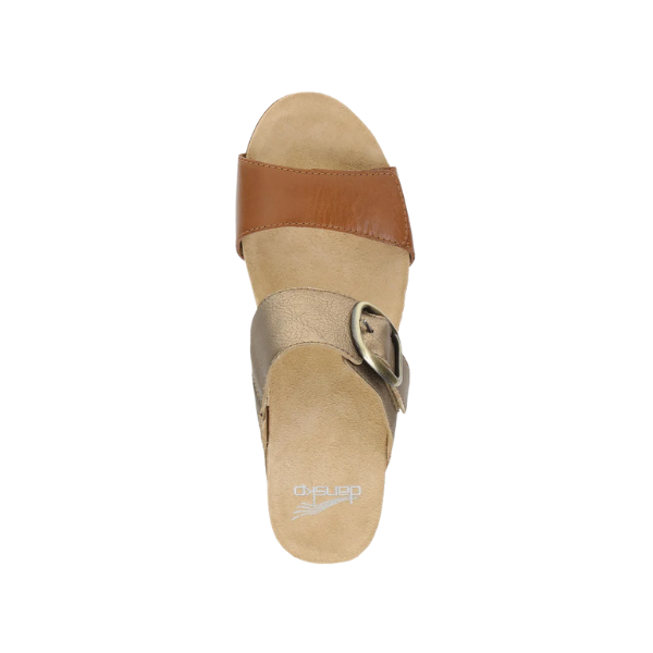 The DANSKO Womens Shannon Gold/Tan is a tan wedge slide sandal with a brown leather toe strap, beige midfoot strap with metallic buckle, and cushioned sole for foot pain relief, shown from above.