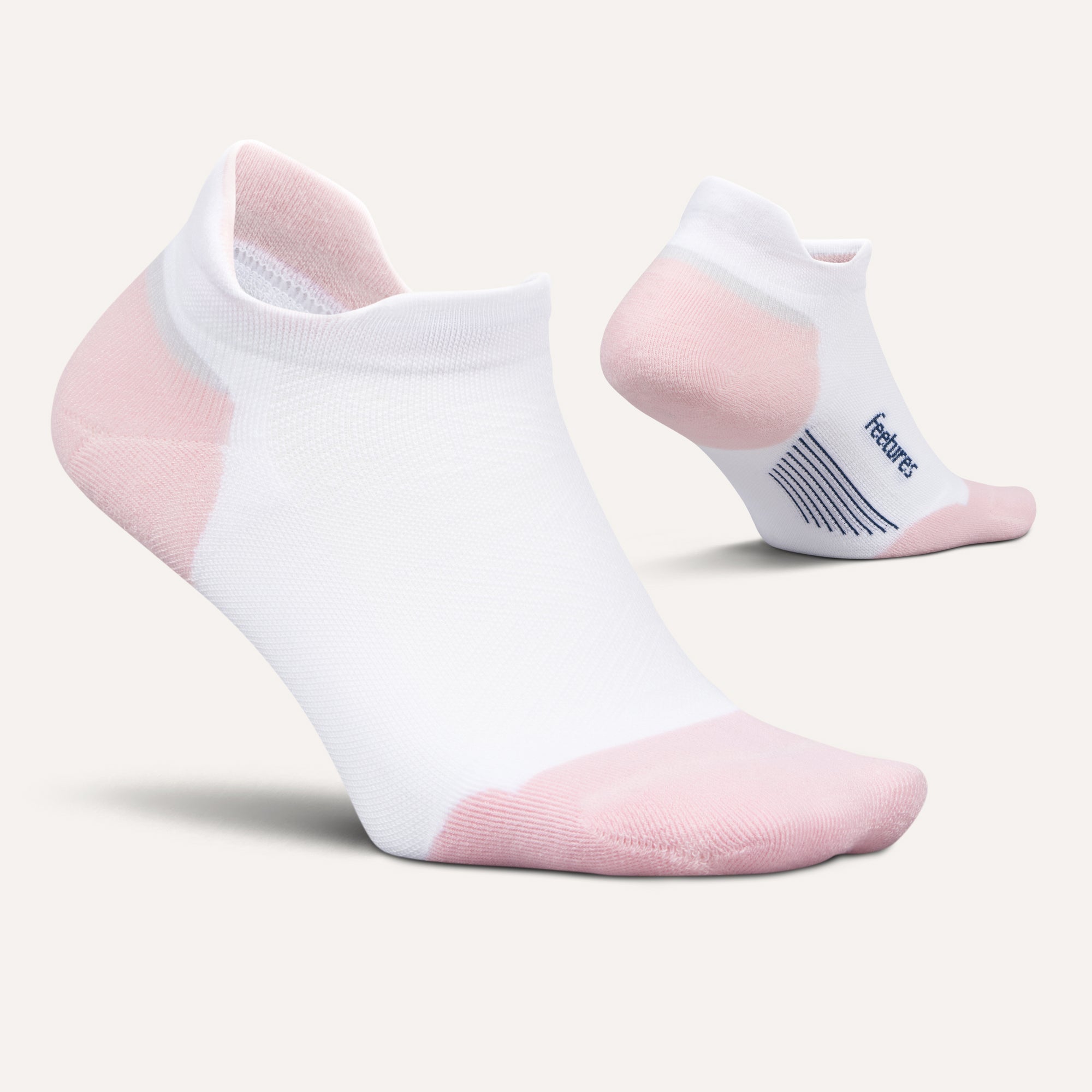 Pair of FEETURES Elite Max Cushion No Show Tab socks in White Rose, targeted arch compression, angled view.