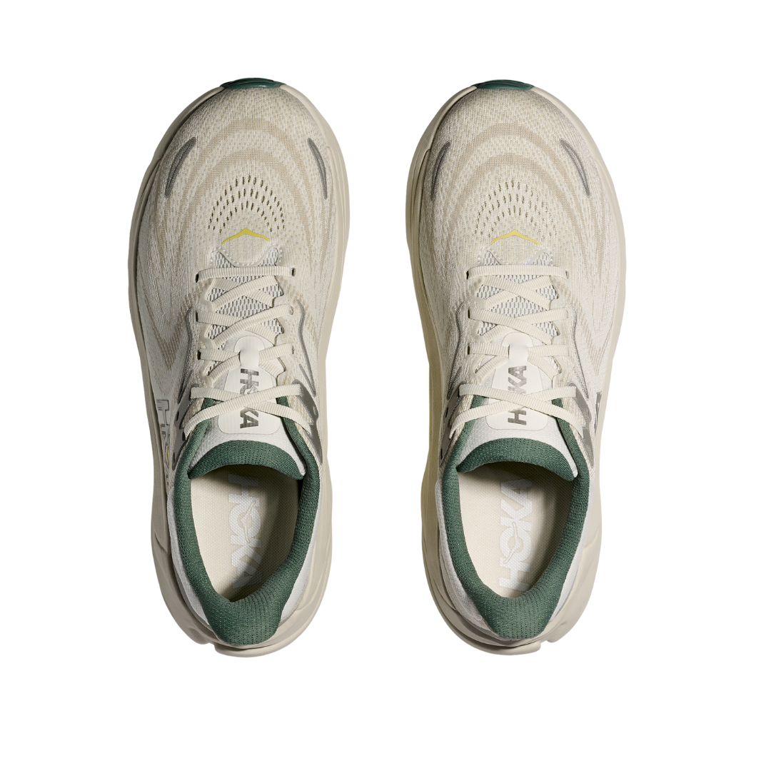 A pair of HOKA Mens Arahi 8 Truffle/Oyster stability shoes with green inner linings, gray and yellow accents, mesh uppers, white laces, and innovative H-frame™ technology, viewed from above on a white background.
