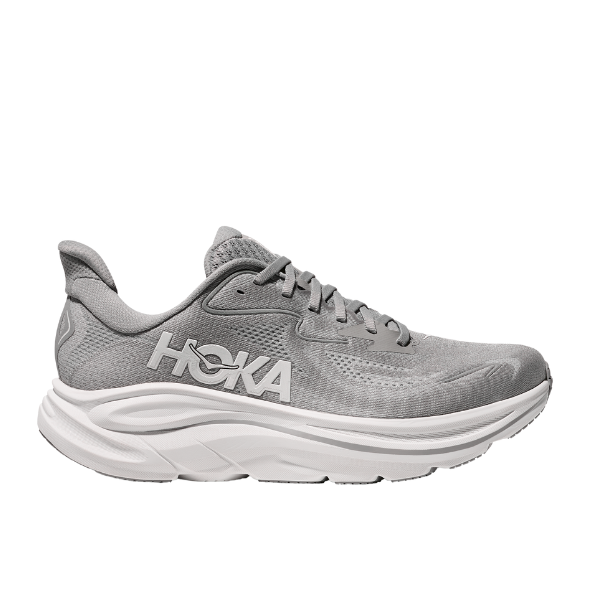 The HOKA Mens Clifton 10 Wide Grey is a cushioned running shoe with a thick white sole, breathable mesh upper, and HOKA logo on the side—designed for foot pain relief. Displayed in profile against a white background.
