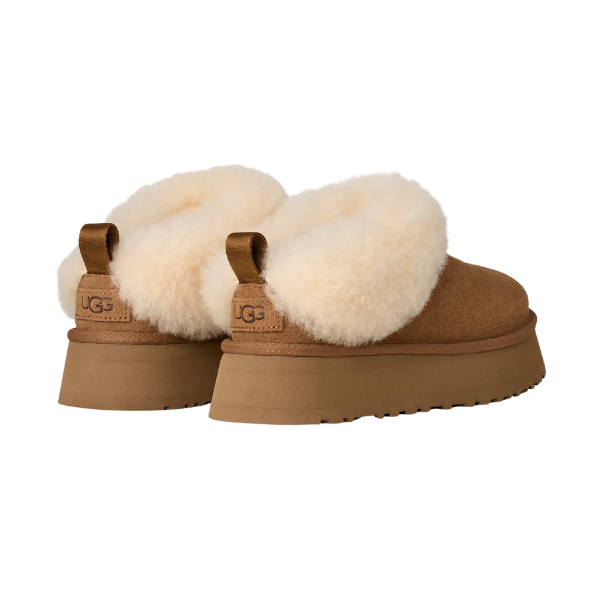A pair of UGG Women's Tazzelle Chestnut slippers featuring thick, fluffy white collars, platform soles, brown pull tabs, and visible UGG branding on the heels are shown from the back angle.