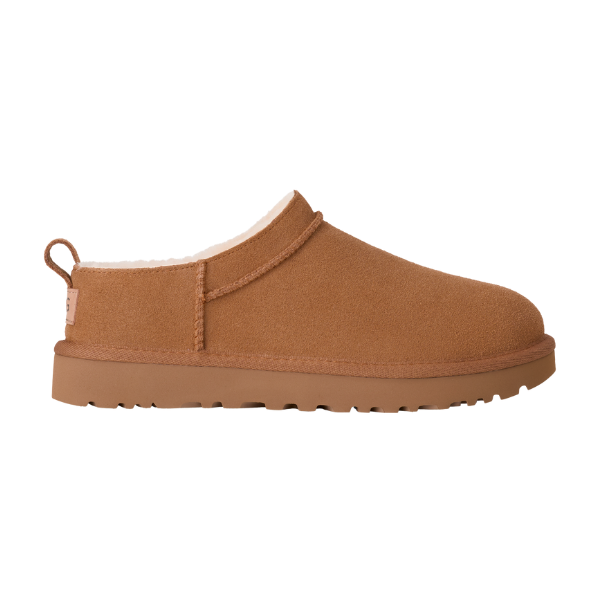 The UGG Women's Classic Micro Chestnut slipper features tan suede, a fluffy white lining, flat sole, and heel pull tab for a cozy UGG look, shown in profile on a white background.