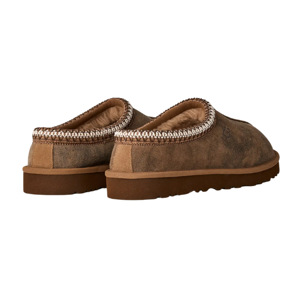UGG Men’s Tasman Baxter Chestnut slip-ons by UGG, shown from back and side against a white background, feature chestnut suede uppers, tan soles, decorative stitching at the opening, and a plush UGGplush lining.