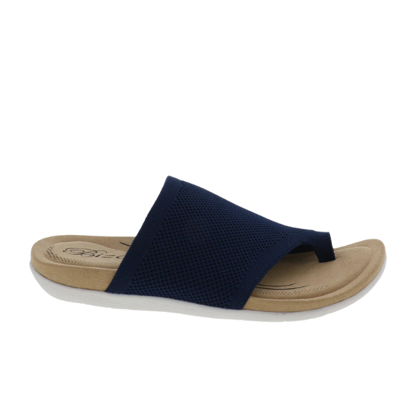 The Biza Womens Lavish Navy by BIZA FOOTWEAR is a stretch knit sandal in navy with a textured strap, tan cushioned footbed for comfort, and white rubber sole, shown from the side on a plain white background.