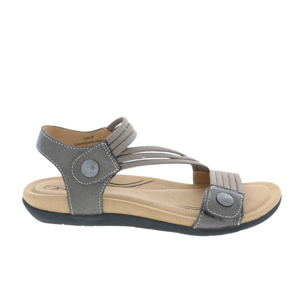 The Biza Womens Luna Pewter sandal by BIZA FOOTWEAR features adjustable Velcro straps, a low wedge heel, cushioned tan insole, two round decorative buttons, and a black rubber outsole, shown in gray on a white background.