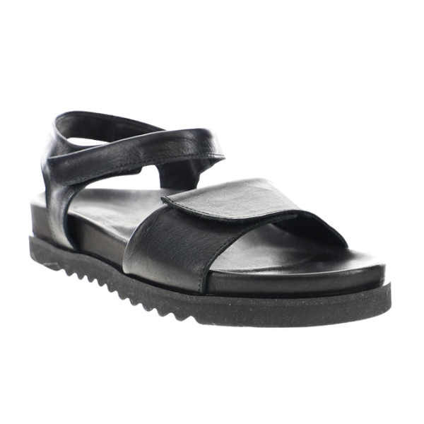 The SOVELLA Womens Chloe Black sandal showcases premium leather straps, adjustable velcro closures, and a thick ridged sole with cushioned footbed for all-day comfort, shown against a white background.