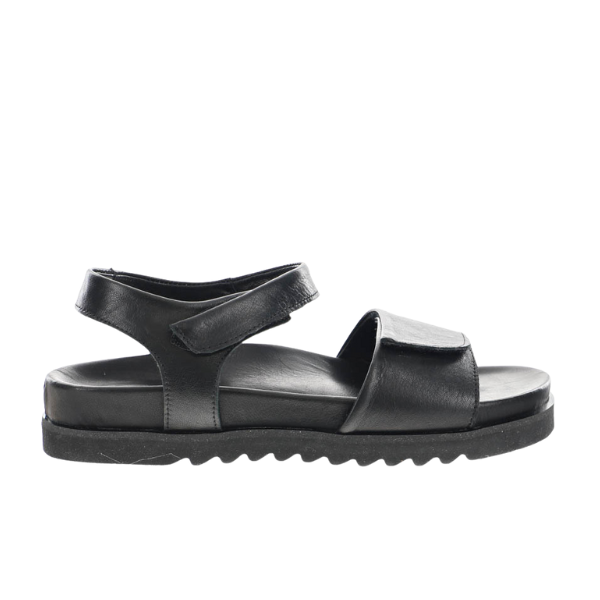 The SOVELLA Womens Chloe Black sandal features premium leather straps with adjustable Velcro at the ankle and front, plus a cushioned footbed and ridged sole for minimalist comfort.