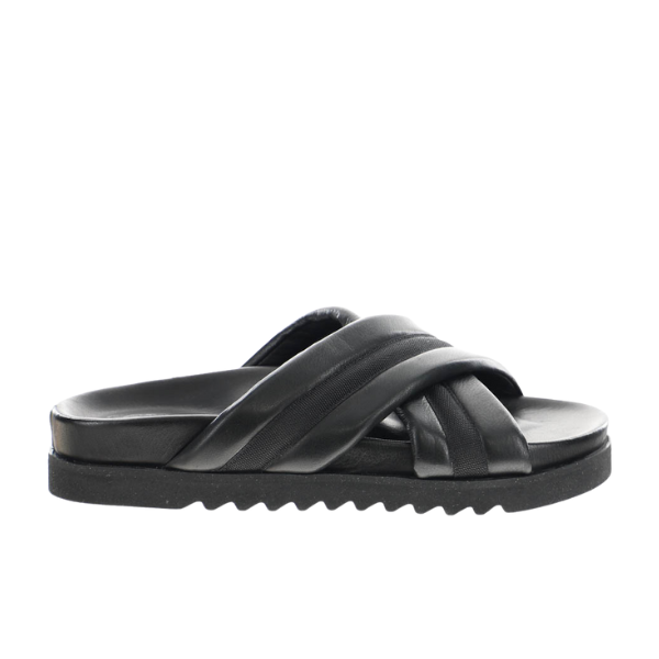 The SOVELLA Sovella Womens Coty Black is a slip-on sandal with crisscrossed padded leather straps, a thick ridged sole, and a cushioned footbed for comfort—ideal for versatile daily wear. Side view shown.