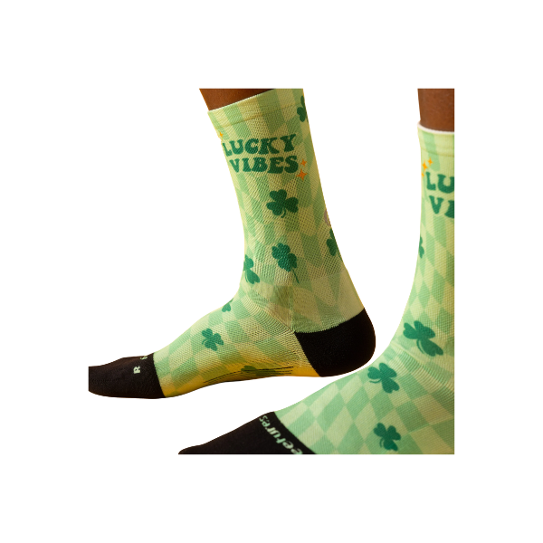 A person wears FEETURES Elite Light Cushion Mini Crew - Lucky Vibes, featuring targeted compression for comfort.