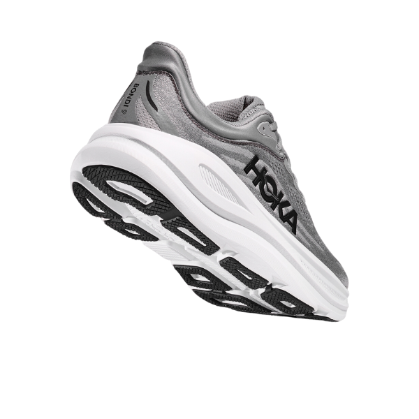 A gray Wide-fit HOKA Mens Bondi 9 shoe in Galactic Grey/Stellar Grey is shown from a low rear angle, displaying its tread and sole. The shoe features the HOKA logo on the side and offers maximum cushioning for foot pain relief.