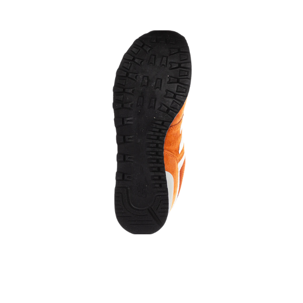 The image shows the sole of a NEW BALANCE Unisex 574 Infield Clay/Sea Salt running shoe with a black tread, providing support and style against foot pain—perfect for those seeking comfort in iconic New Balance footwear.