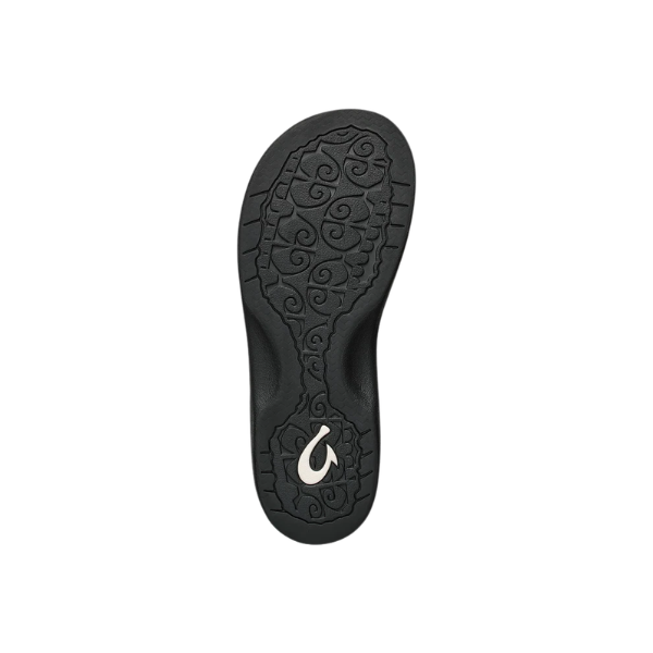 OLUKAI Women’s Ohana Lahi sandal in White Sand/Black with swirl sole and silver fish hook, on a white background.