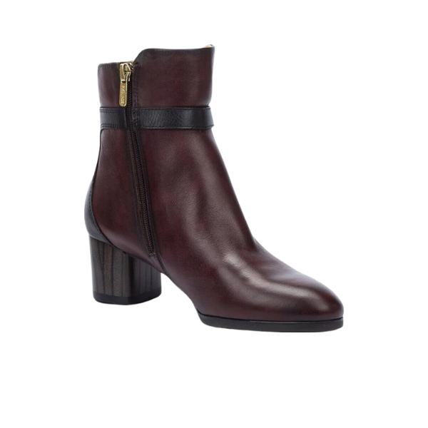 The PIKOLINOS Women’s Calafat Dark Brown ankle boot features a side zipper, black strap detail, and chunky heel, combining style and comfort in premium calfskin leather.