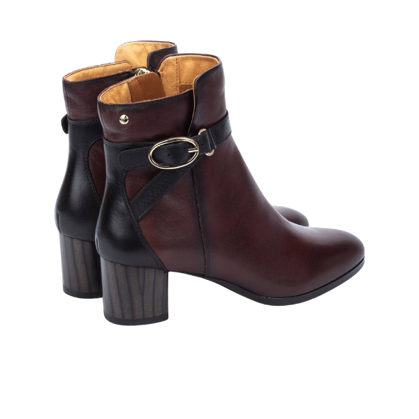 PIKOLINOS Pikolino Women’s Calafat Dark Brown ankle boots feature calfskin leather, black back accents, chunky striped heels, and a decorative gold-buckle strap—stylish and comfortable footwear for any occasion.