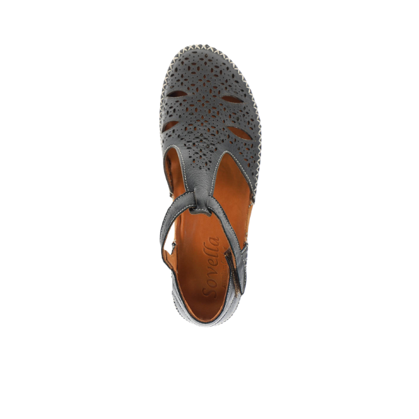 Top view of a single Sovella Womens Sabrina Black sandal by SOVELLA, featuring a closed toe, perforated floral pattern, T-strap design, and brown insole. This comfort footwear is designed to help provide foot pain relief.