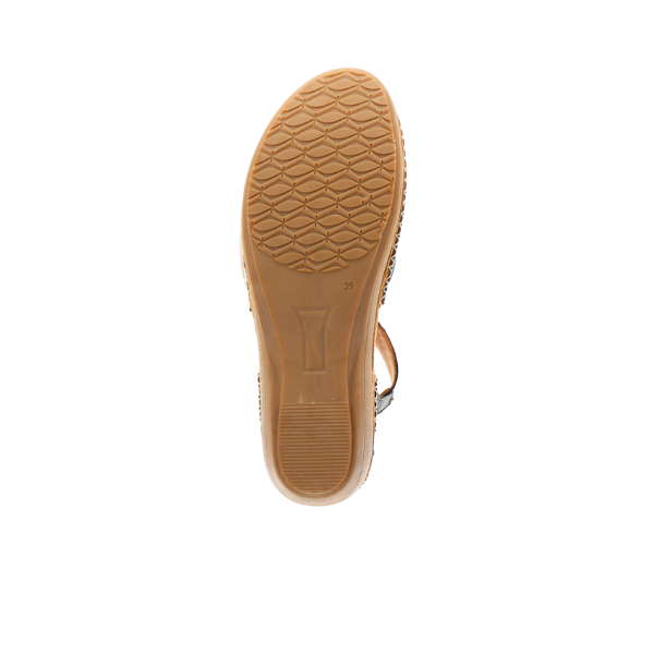 A single SOVELLA Womens Sabrina Black sandal is shown from the bottom, displaying a textured brown rubber sole with a pattern and size 39 mark near the arch. This comfort footwear has a slightly raised heel for foot pain relief.