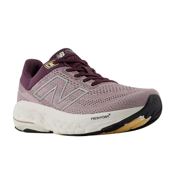 The New Balance Womens Fresh Foam 860v14 Plum is an athletic shoe in mauve and maroon with a white and black sole, signature “N” logo, Stability Plane for support, and a breathable mesh upper.