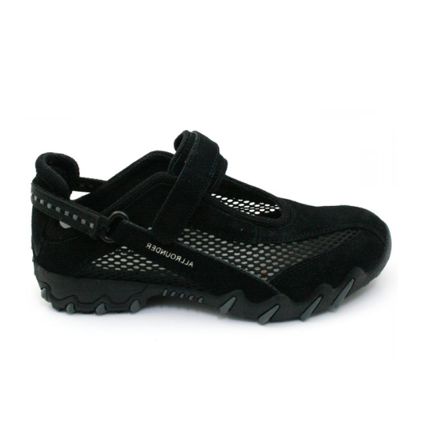 The Allrounder Womens Niro Black by ALLROUNDER is a black athletic shoe with a rugged sole, mesh panels for breathability, and a Velcro strap. It features SHOCK ABSORBER technology for added comfort, with ALLROUNDER printed on the side.