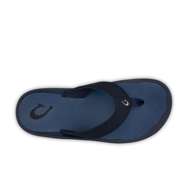 A single OLUKAI Mens Ohana sandal in Deep Blue/White, featuring a fishhook-shaped logo on the heel and strap, thick straps, and a dark blue footbed—water-resistant and shown from above on a white background.