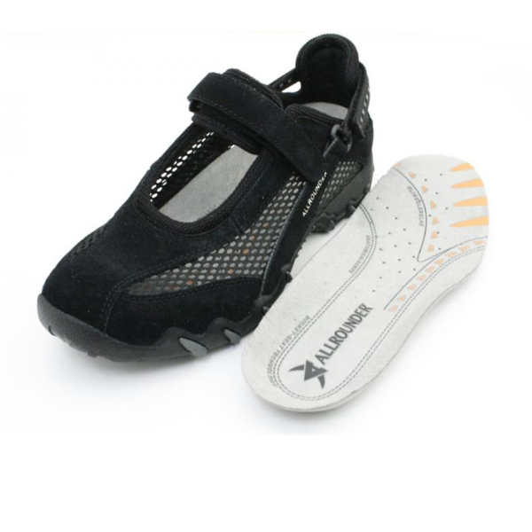 The Allrounder Womens Niro Black sneaker by ALLROUNDER features black mesh, a Velcro strap, and comes with a removable gray insole showing orange accents, ALLROUND branding, and SHOCK ABSORBER technology for foot comfort.
